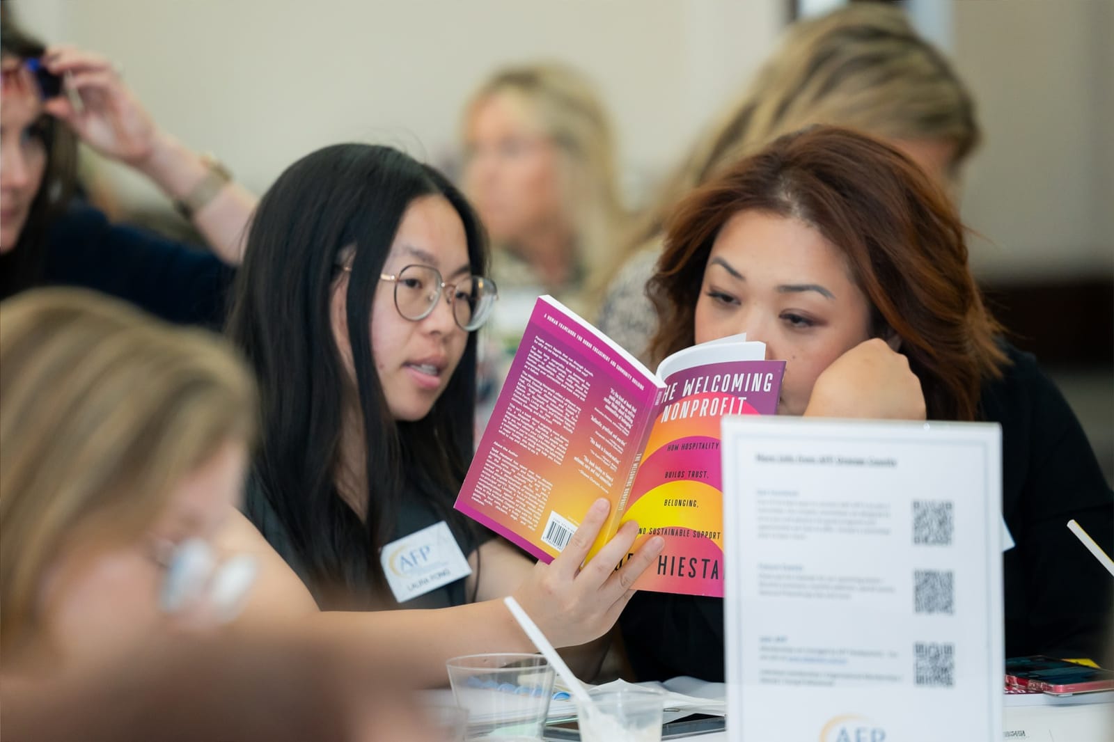 Two attendees reading The Welcoming Nonprofit together at an AFP chapter meeting